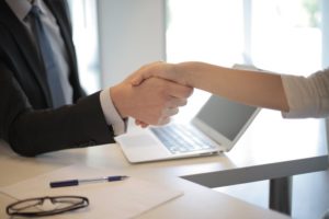 Business owner hiring online business coach with a handshake. 